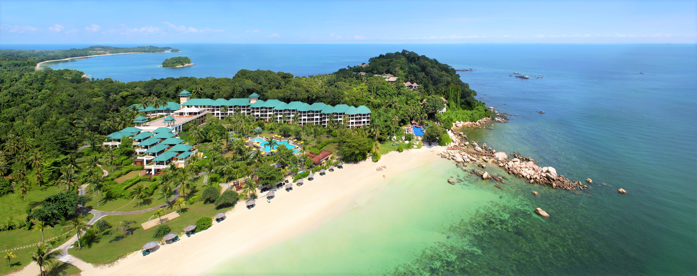 Angsana Bintan resort nestled between lush forest and a scenic beach, overlooking the ocean.